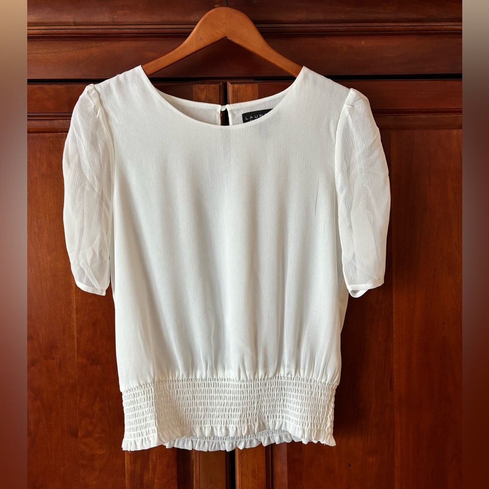 Laundry NWOT white short-sleeved blouse with a smocked hem.